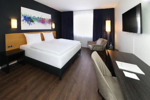 a bedroom with a large white bed and a couch at Wyndham Garden Potsdam in Potsdam