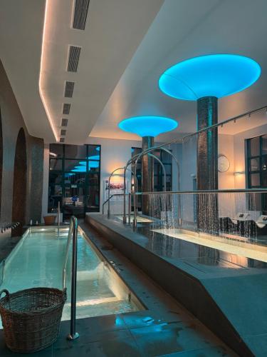 a large swimming pool in a building with blue lights at Hotel Balneario de Lanjarón in Lanjarón
