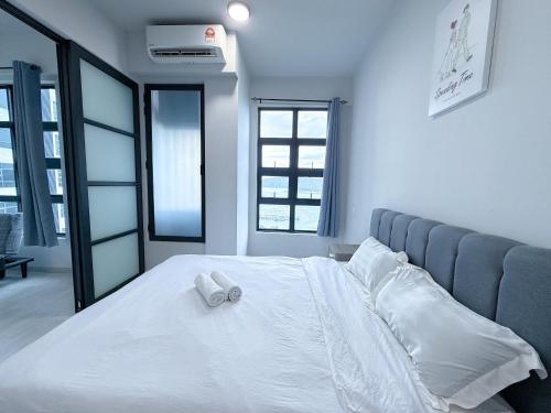 a white bed with two towels on top of it at 适合全家入住 Jesselton Quay高楼层日落景公寓 近Suria & Gaya街 Perfect for Families High-Floor Sunset Condo at Jesselton Quay Near Suria and Gaya Street in Kota Kinabalu