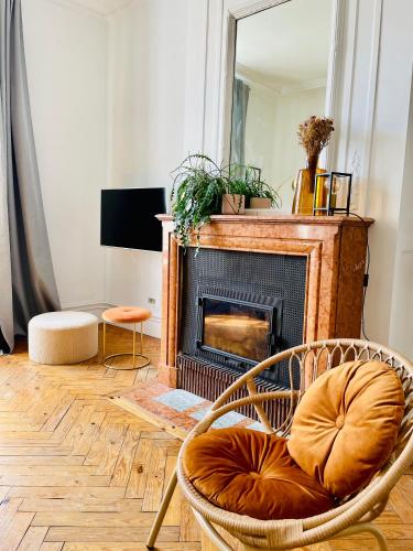 - un salon avec une chaise et une cheminée dans l'établissement Le 52 - Appartement haut de gamme plein centre Lille - parking, à Lille
