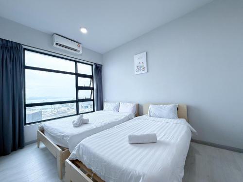 two beds in a room with a large window at 适合全家入住 Jesselton Quay高楼层日落景公寓 近Suria & Gaya街 Perfect for Families High-Floor Sunset Condo at Jesselton Quay Near Suria and Gaya Street in Kota Kinabalu