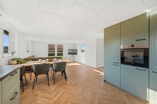 a kitchen and dining room with a table and chairs at Modern Holiday Home With 3 Bedrooms, Completely Renovated In 2025 And Located Close To Rinkøbing Fjord in Skjern