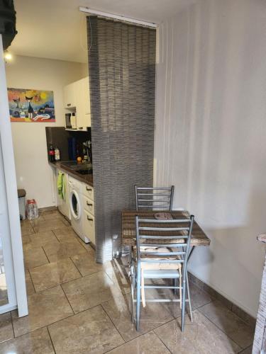 une salle à manger avec une table et des chaises dans une cuisine dans l'établissement CALVI STUDIO TERRASSE PLAGe, à Calvi