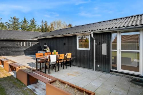 a patio with a table and chairs on it at Modern Holiday Home With 3 Bedrooms, Completely Renovated In 2025 And Located Close To Rinkøbing Fjord in Skjern