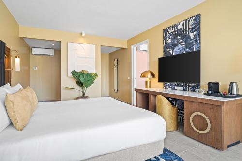 a hotel room with a bed and a flat screen tv at The Rif At Mangrove Beach Corendon Curacao All-Inclusive, Curio by Hilton in Willemstad