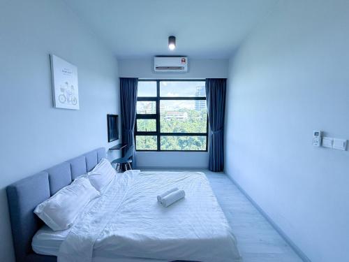 a bedroom with a white bed with a window at 适合全家入住 Jesselton Quay高楼层日落景公寓 近Suria & Gaya街 Perfect for Families High-Floor Sunset Condo at Jesselton Quay Near Suria and Gaya Street in Kota Kinabalu