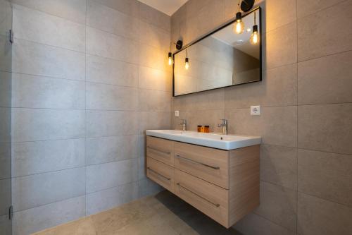 a bathroom with a sink and a mirror at Residence Noordstaete - Vakantieappartement Kluut de Luxe in Burgh Haamstede