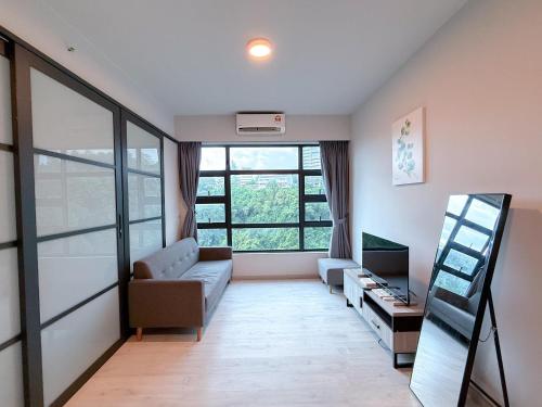 a living room with a couch and a tv at 适合全家入住 Jesselton Quay高楼层日落景公寓 近Suria & Gaya街 Perfect for Families High-Floor Sunset Condo at Jesselton Quay Near Suria and Gaya Street in Kota Kinabalu