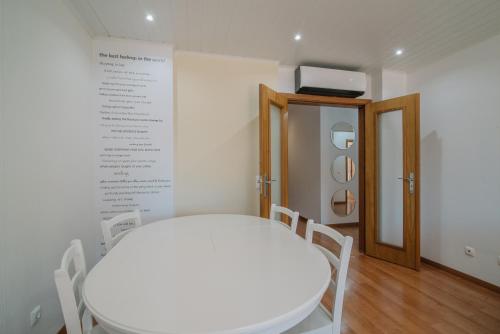 a white table and chairs in a room at Casa da Rita in Olhão