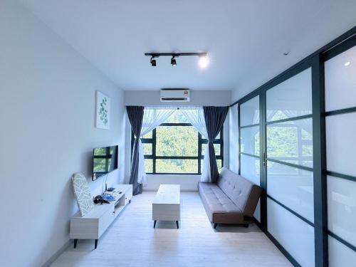 a living room with a couch and a large window at 适合全家入住 Jesselton Quay高楼层日落景公寓 近Suria & Gaya街 Perfect for Families High-Floor Sunset Condo at Jesselton Quay Near Suria and Gaya Street in Kota Kinabalu