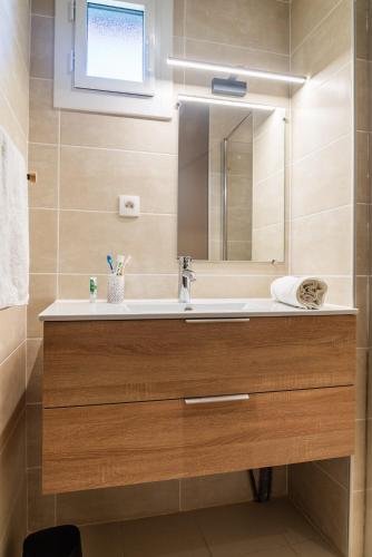 une salle de bain avec un lavabo et un miroir dans l'établissement Village de Gîtes de La Canourgue, à La Canourgue