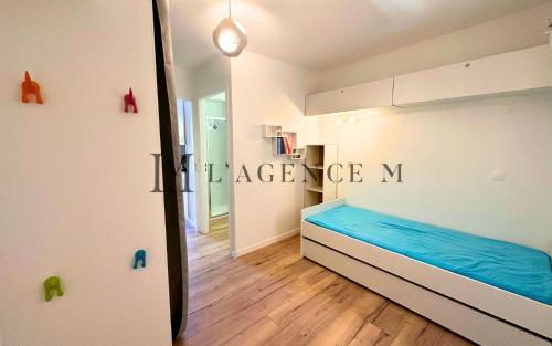 une chambre avec un lit bleu et un miroir dans l'établissement Studio Pinea Les pieds dans l'eau CALVI, à Calvi