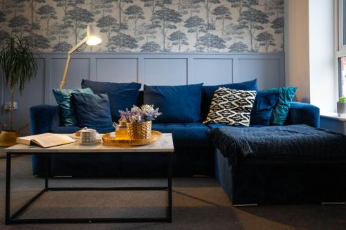 un soggiorno con un divano blu e un tavolo di 1 Bed House , Free WiFi,Free Parking,Leasure,Business a Swansea