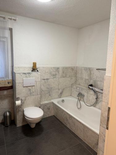 Un baño con inodoro, bañera y lavabo. en Ferienwohnung in Thale, en Thale