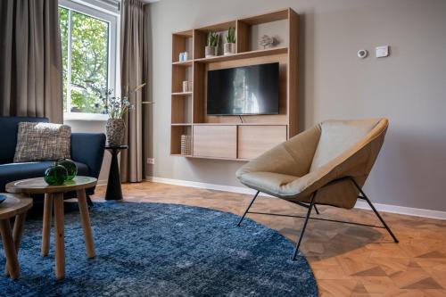 a living room with a chair and a tv at Residence Noordstaete vakantieappartement Lepelaar in Burgh Haamstede