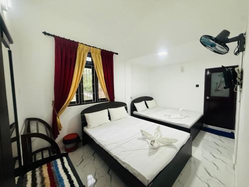 a bedroom with two beds and a tv in it at St Jude Holiday Resort in Talawakele