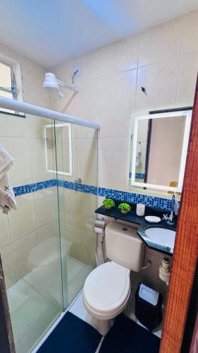 a bathroom with a toilet and a sink and a shower at Ap5- atrás da Passarela do Caranguejo Atalaia - térreo - 2 ar cond in Aracaju