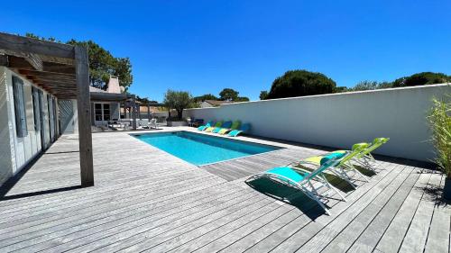 une terrasse avec des chaises et une piscine dans l'établissement Superbe villa entièrement rénovée avec piscine à proximité de la plage, à Sainte-Marie de Ré