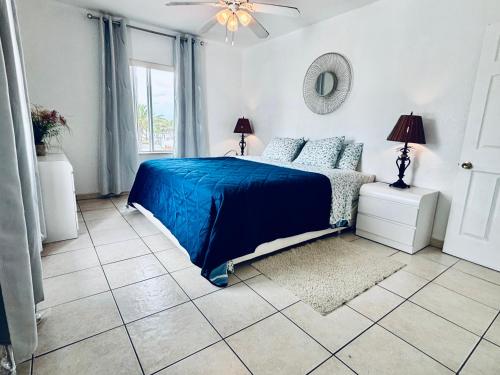 a bedroom with a blue bed and a window at Beach Tide Motel in Hollywood