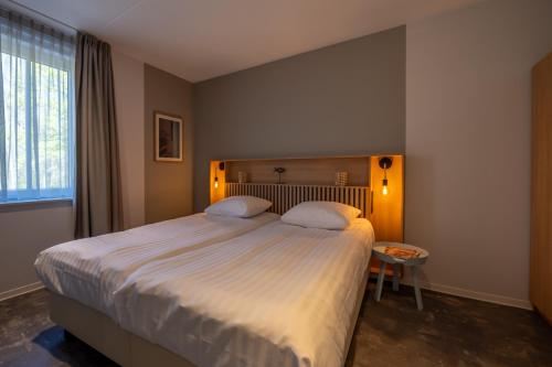 ein Schlafzimmer mit großem Bett und Fenster in der Unterkunft Residence Noordstaete - Vakantieappartement Lepelaar de Luxe in Burgh Haamstede