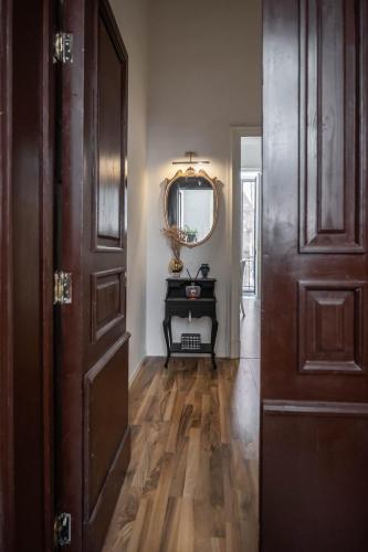 a hallway with a door and a mirror and a table at Beretti Home in Catania