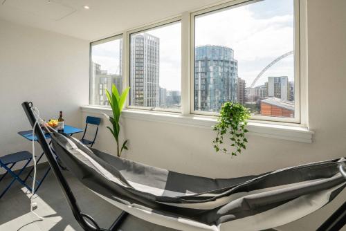 a room with a chair and a table and window at Wembley Stadium Apartments by Sleepy Lodge London in London