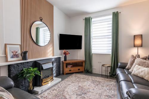 a living room with a couch and a fireplace at Ness Heights, Spacious City Centre Townhouse in Inverness