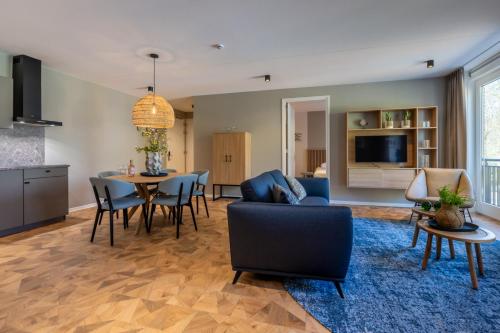 a living room with a table and a dining room at Residence Noordstaete - Vakantieappartement Lepelaar de Luxe in Burgh Haamstede