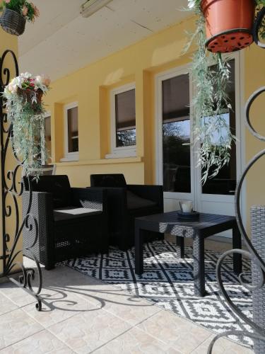 un patio avec des tables, des chaises et des fenêtres dans l'établissement Maison avec jardin au calme proche de paris (30mn), à Longpont-sur-Orge