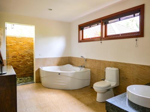 un bagno con vasca, WC e lavandino di Tropical Garden 3br Villa Sansuk Private Pool a Ban Mae Nam