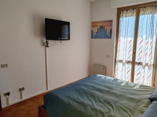 a bedroom with a bed and a tv on the wall at Condominio melograno in Rosignano Solvay