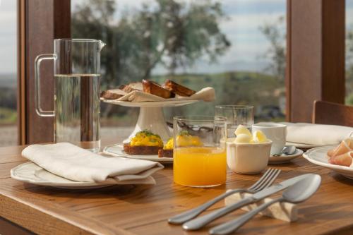 a wooden table with breakfast foods and orange juice at Casale Oleo in Montiano