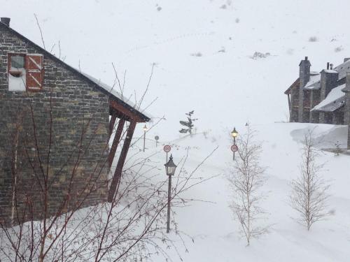 a building in the snow with two street lights at Chalet Anayet Lodge Luxury 5 Stars in Formigal in Formigal