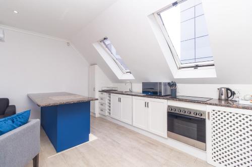 an attic kitchen with skylights and a stove at Neighbourgood Ravenscraig in Cape Town