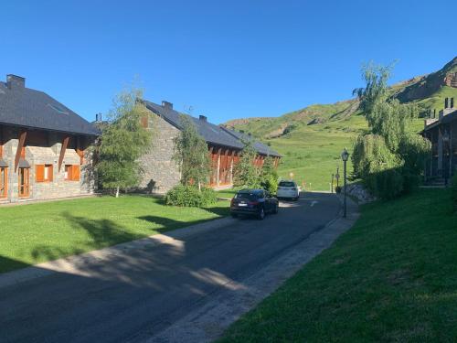 a car driving down a road next to a house at Chalet Anayet Lodge Luxury 5 Stars in Formigal in Formigal