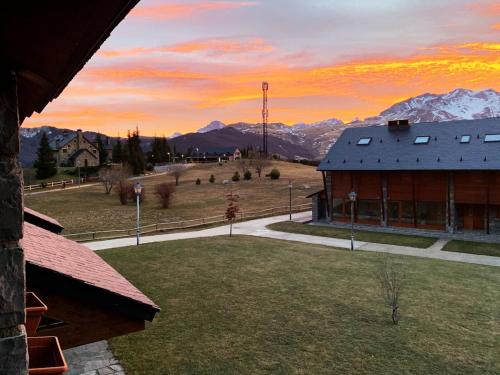 a view of a building with mountains in the background at Chalet Anayet Lodge Luxury 5 Stars in Formigal in Formigal