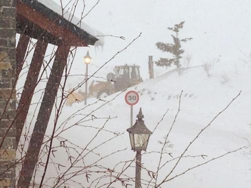 a street light with a sign in the snow at Chalet Anayet Lodge Luxury 5 Stars in Formigal in Formigal