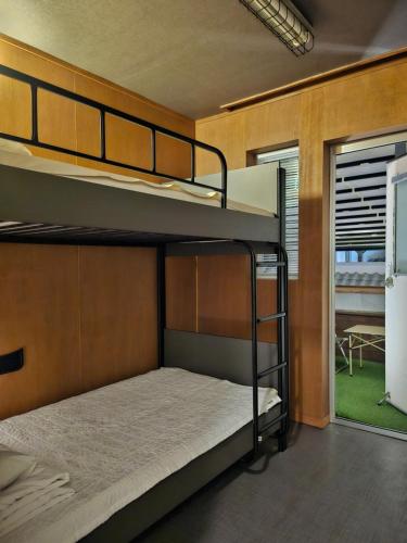 two bunk beds in a room with a window at Mido Hostel in Seogwipo