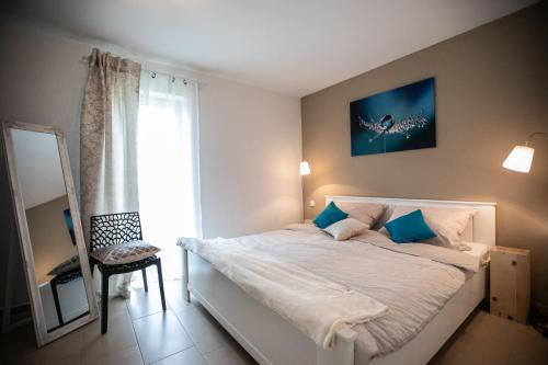 a bedroom with a white bed with a window at Claudia's Seeherz in Wasserburg am Bodensee