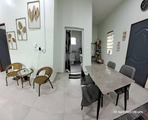 Un comedor con mesa y sillas en Laman Abah Staycation, en Jenjarum