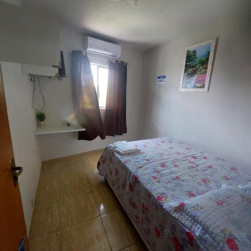 a small bedroom with a bed and a window at Flat estação in Juazeiro do Norte