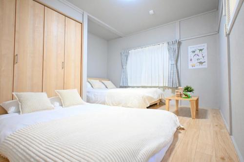 a bedroom with two beds and a window at JAVA HOUSE Sumiyoshiー10min Nambaー40min KIX in Osaka