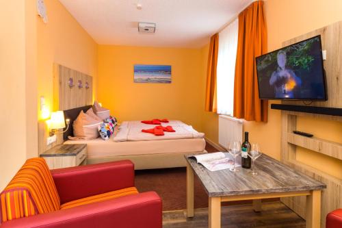 a hotel room with a bed and a table and a tv at Appartementhäuser Achterwasserblick in Ostseebad Koserow