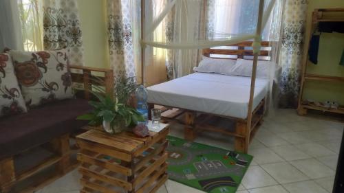 a bedroom with a bed and a couch in it at Mount Zion Guest House, Mtwapa Mtomondoni in Mombasa
