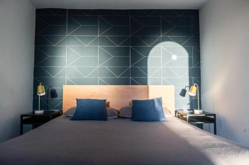 a bedroom with a large bed with a blue wall at Suite 5 in Cala del Moral
