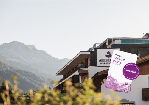 a sign on a building with a mountain in the background at Anthony's Life&Style Hotel in Sankt Anton am Arlberg