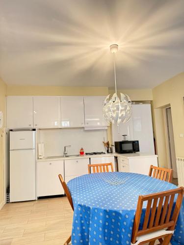 une cuisine et une table avec une nappe bleue dessus dans l'établissement Le Favorin 1, à Arles