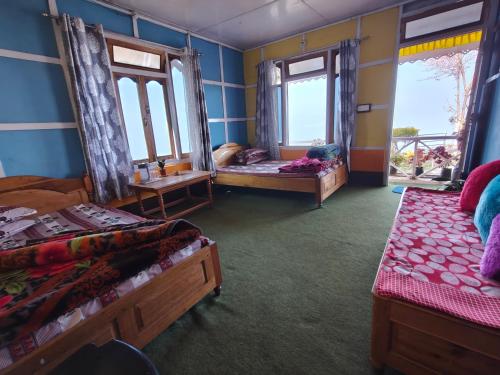 a room with two beds and two windows at Ekta Homestay in Kalimpong