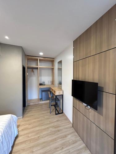 邦咯Alva Boutique Chalet Pangkor的一间卧室配有一张床,墙上设有一台平面电视