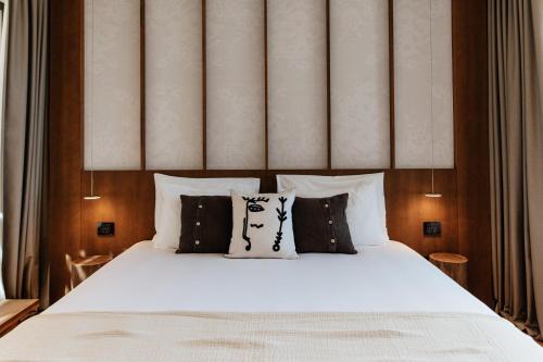 a bedroom with a bed with black and white pillows at Maslinica Maison Collection in Stari Grad